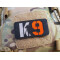 JTG K9 LaserCut Patch, schwarz, Cordura, reflektierendes Logo und Schriftzug, mit Klettrückseite